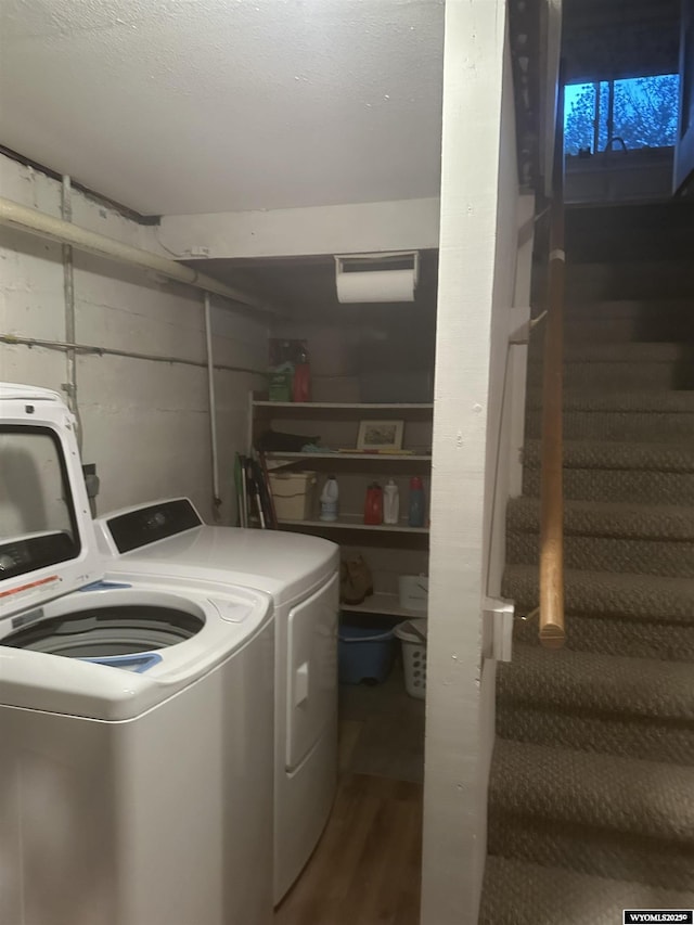 washroom with laundry area, washing machine and dryer, and wood finished floors