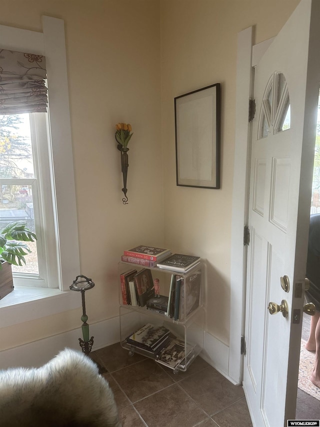 entrance foyer featuring dark tile patterned flooring and baseboards