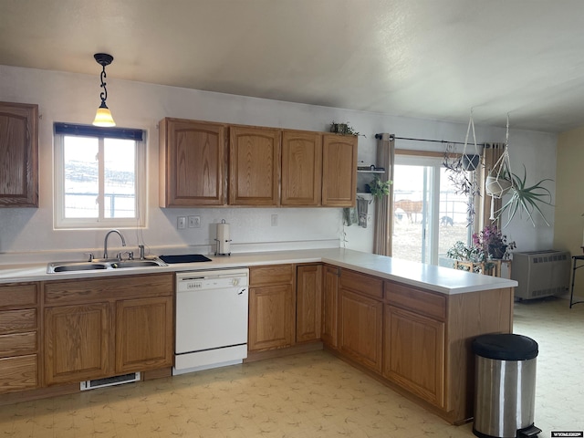 kitchen with light countertops, white dishwasher, and a sink