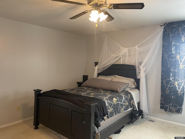 carpeted bedroom with ceiling fan and baseboards