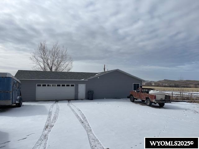 view of snow covered exterior featuring an attached garage