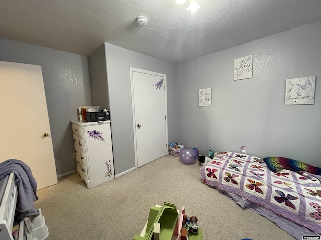 bedroom with a textured ceiling and light colored carpet