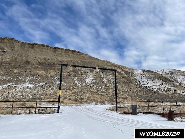 yard layered in snow featuring fence and a mountain view