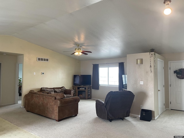 carpeted living room featuring a fireplace, a ceiling fan, visible vents, vaulted ceiling, and baseboards