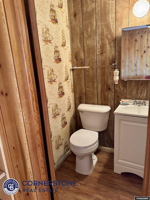 bathroom featuring vanity, wood finished floors, toilet, and baseboards