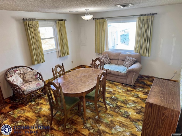 dining room with visible vents and a textured ceiling