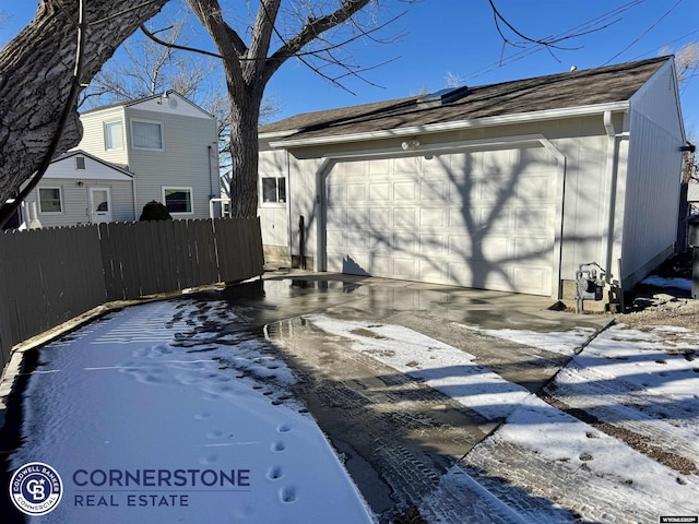 exterior space featuring an outbuilding, a detached garage, and fence