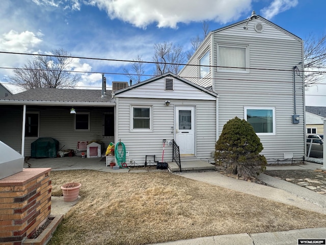 view of front of home with entry steps, a patio, and a front lawn