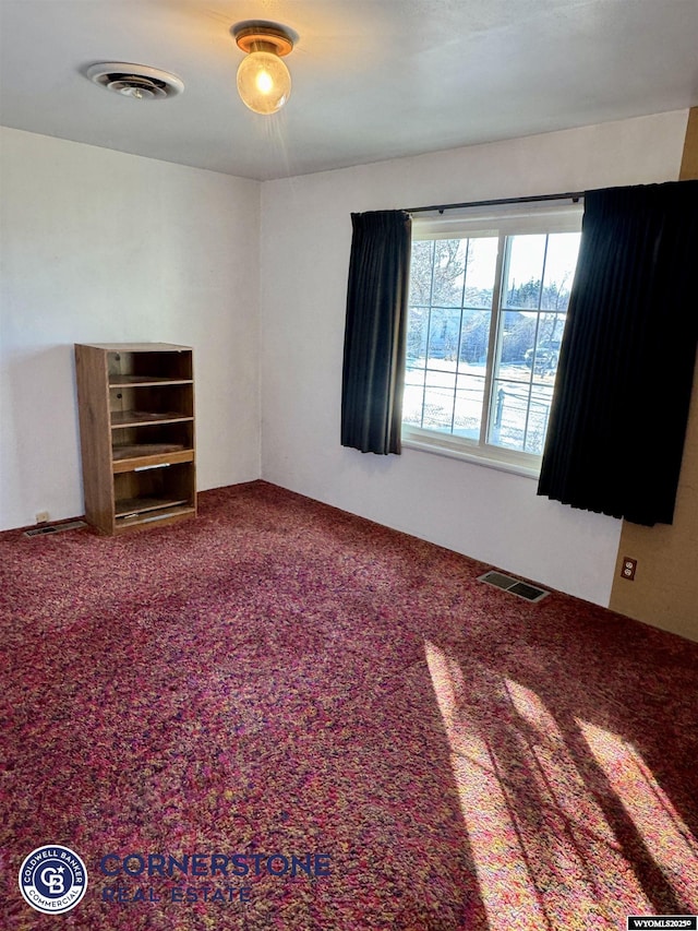 empty room with visible vents and carpet flooring