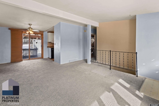 carpeted spare room with a ceiling fan and visible vents