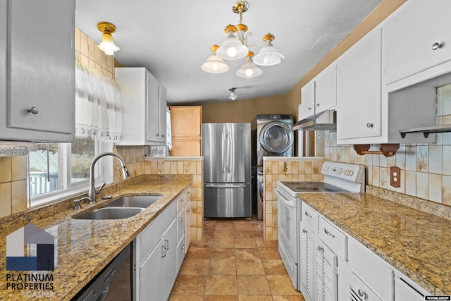 kitchen featuring white range with electric cooktop, stacked washer and clothes dryer, freestanding refrigerator, white cabinetry, and a sink