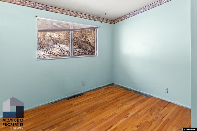 empty room with visible vents and wood finished floors