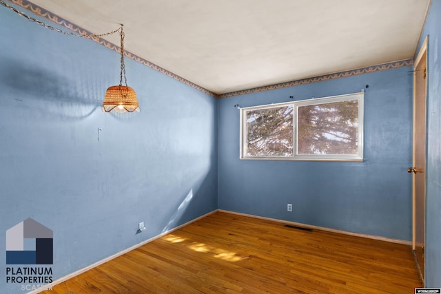 empty room featuring wood finished floors and visible vents