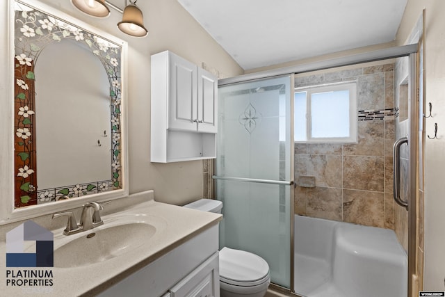 bathroom with tiled shower, vanity, and toilet