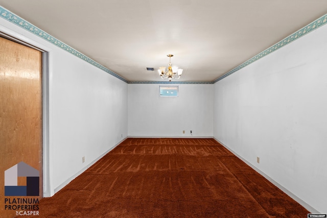 spare room with dark carpet and an inviting chandelier