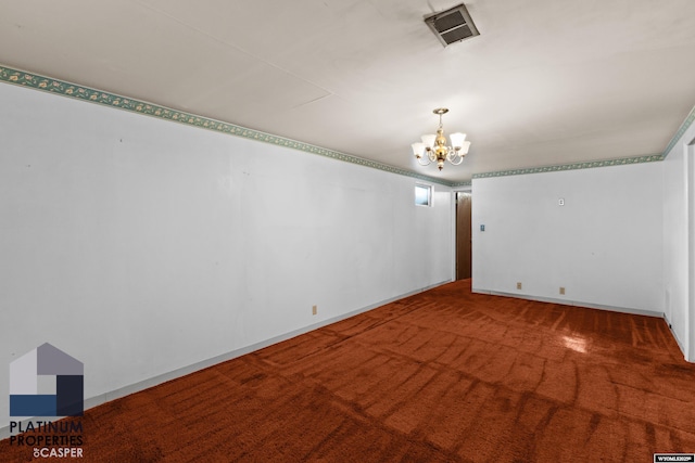 carpeted spare room featuring baseboards, visible vents, and a chandelier