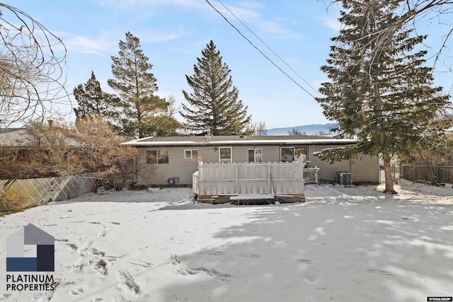 snow covered house with central AC unit and fence