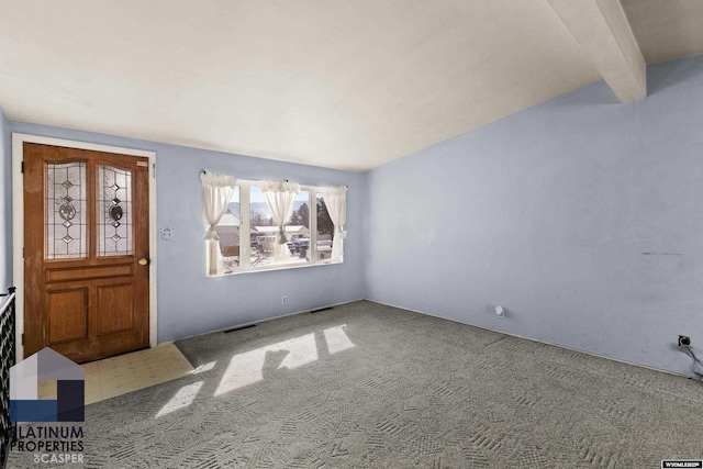 carpeted foyer entrance featuring visible vents and beamed ceiling