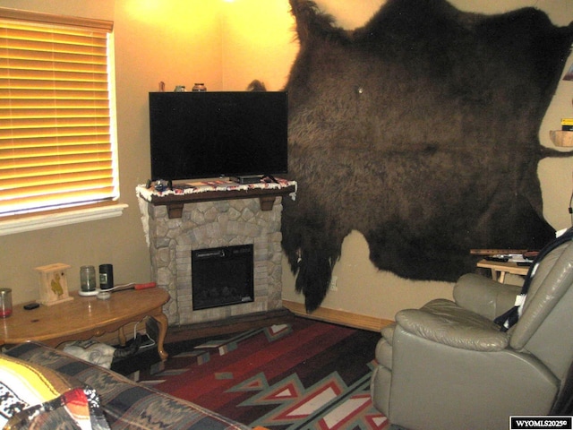 living room featuring a stone fireplace
