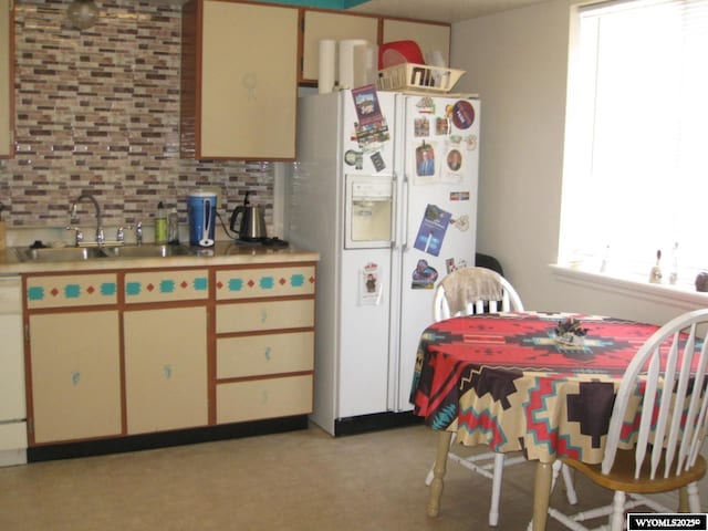 kitchen featuring white appliances, a sink, light countertops, light floors, and backsplash