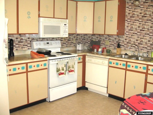 kitchen featuring white appliances, light countertops, a sink, and backsplash