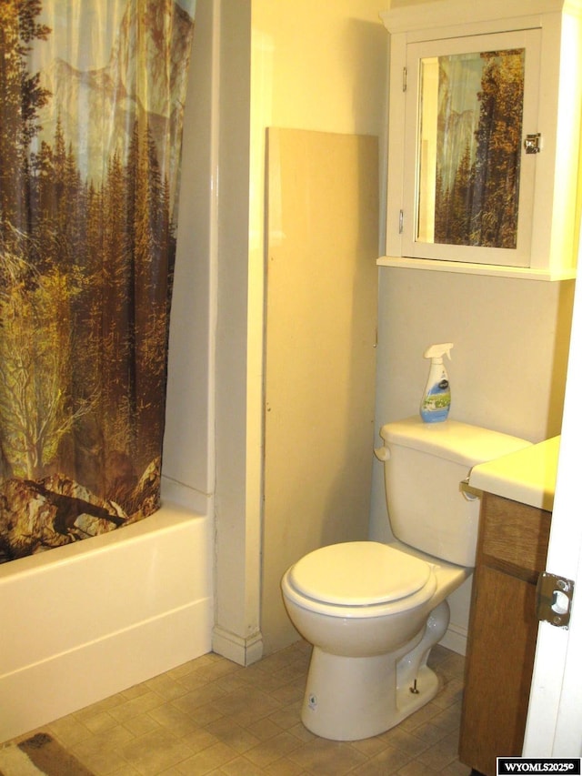 bathroom featuring toilet, shower / bath combo with shower curtain, and vanity