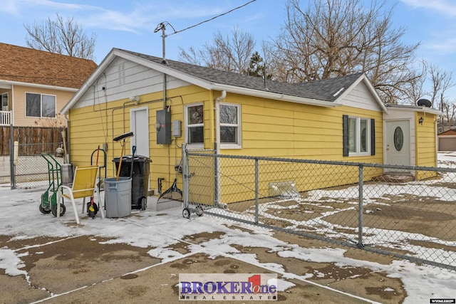 view of front of home with roof with shingles and fence