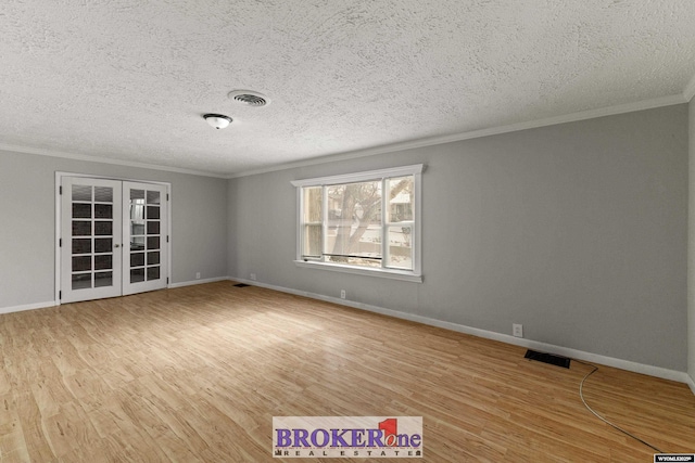 spare room with light wood-style floors, french doors, visible vents, and ornamental molding