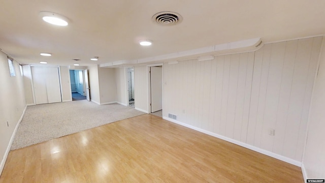 empty room featuring wood finished floors, visible vents, and baseboards