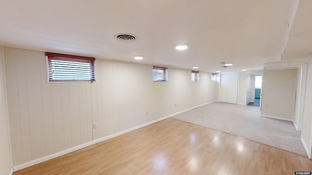 basement with light wood-style floors, baseboards, and visible vents