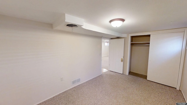 unfurnished bedroom with a closet, visible vents, and light carpet