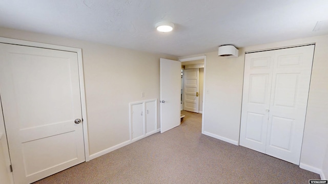 unfurnished bedroom with a closet, carpet flooring, and baseboards