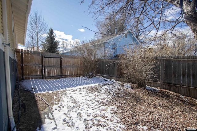 yard covered in snow featuring a fenced backyard