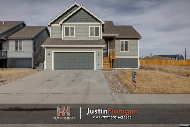 craftsman-style house featuring a garage, driveway, fence, and roof with shingles