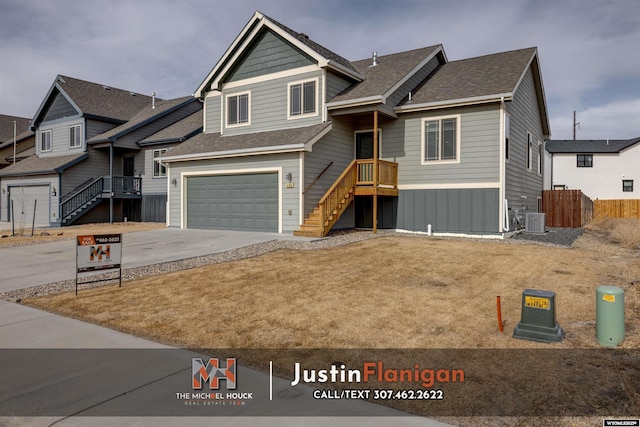 craftsman-style home with driveway, a garage, a shingled roof, fence, and cooling unit