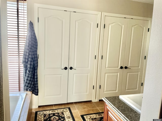 bathroom with a closet, tile patterned flooring, and vanity