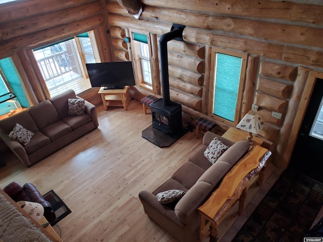 living area with a wood stove and wood finished floors