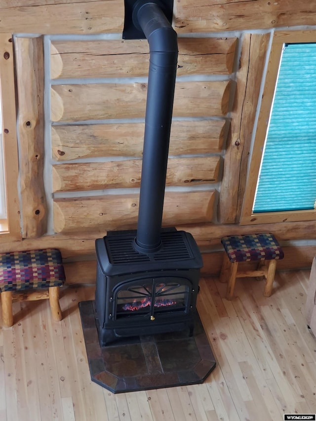 interior details featuring rustic walls, wood finished floors, and a wood stove