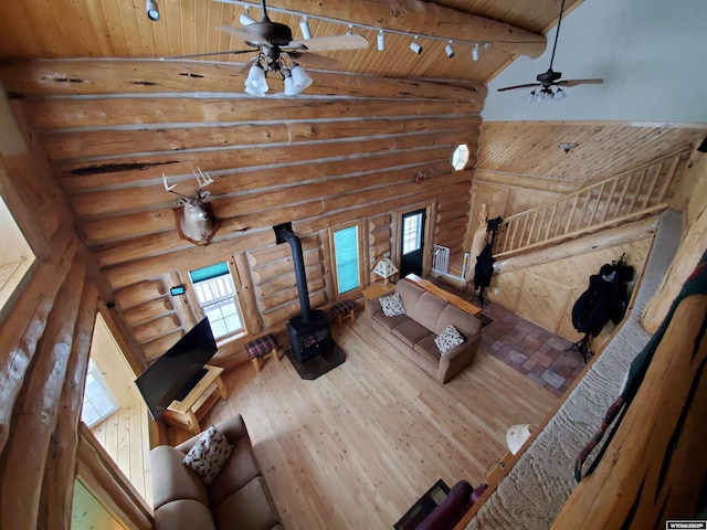 living room with wood ceiling, a wood stove, track lighting, wood finished floors, and high vaulted ceiling