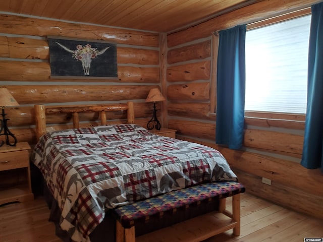 bedroom featuring wood ceiling, log walls, and wood finished floors