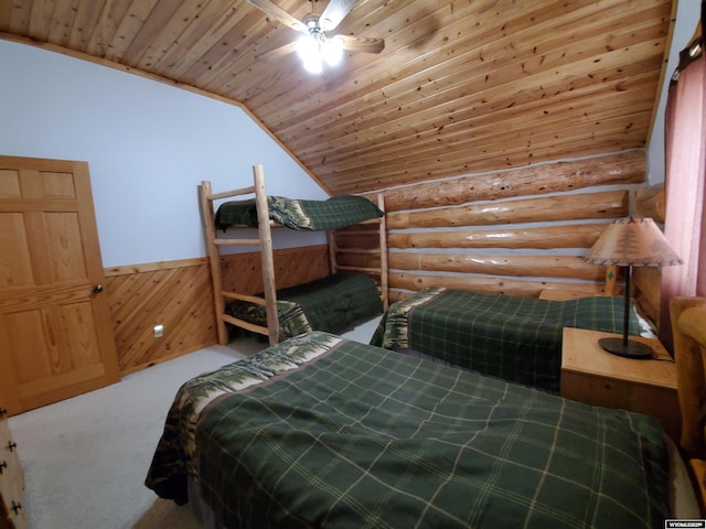 bedroom with lofted ceiling, a wainscoted wall, carpet flooring, wood ceiling, and log walls