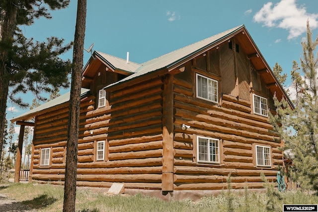 view of side of property with log siding and metal roof