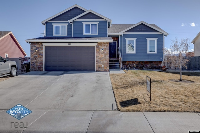 view of front of home featuring a garage, concrete driveway, and stone siding