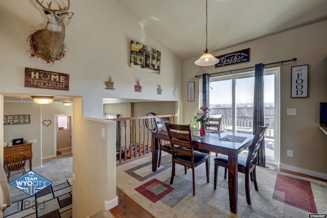 dining space with vaulted ceiling and baseboards