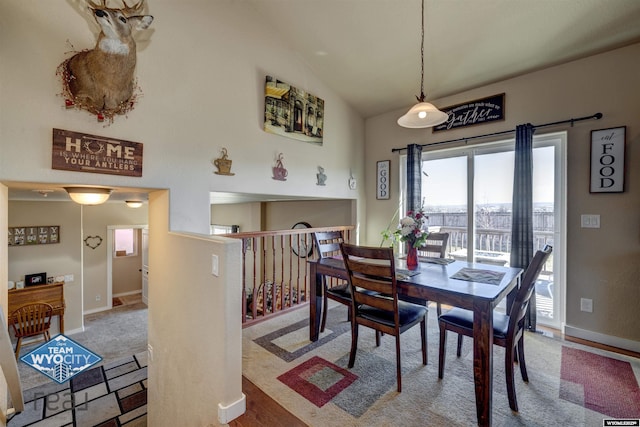 dining area featuring vaulted ceiling and baseboards