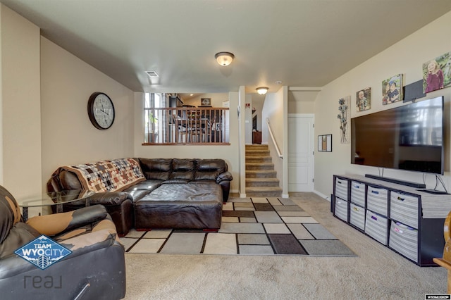 living area with stairs, baseboards, visible vents, and light colored carpet