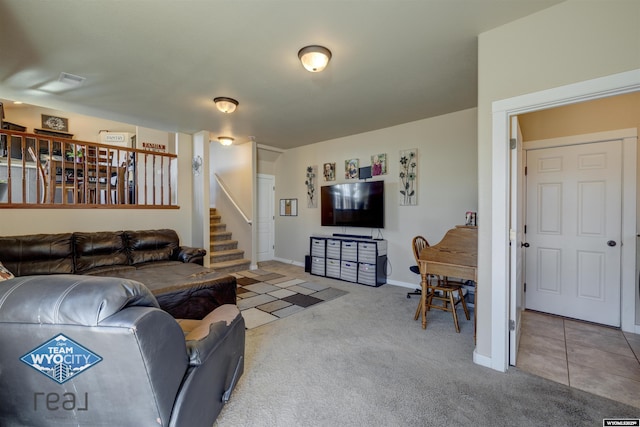 carpeted living area featuring tile patterned flooring, baseboards, and stairs