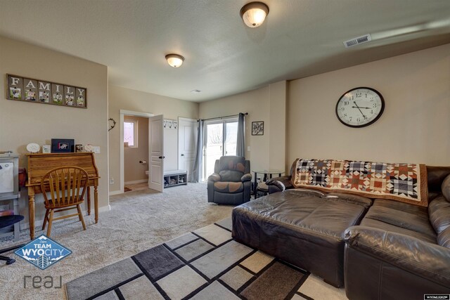 living room with baseboards, visible vents, and light colored carpet