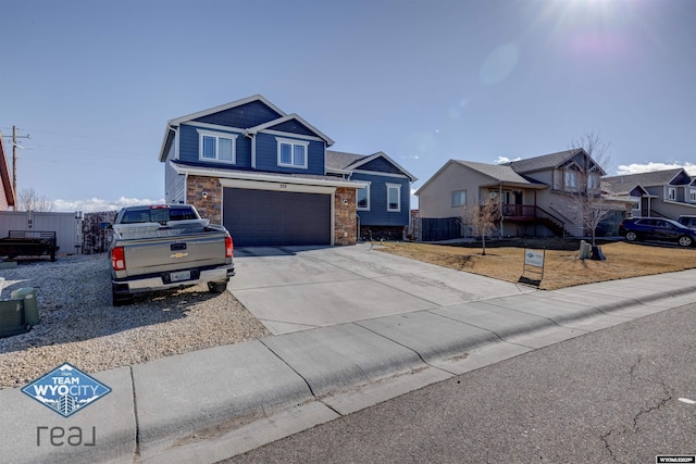 view of front of house featuring a garage, stone siding, a residential view, and driveway