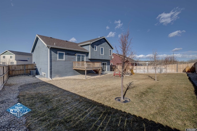 rear view of house featuring a deck, central AC unit, a lawn, and a fenced backyard